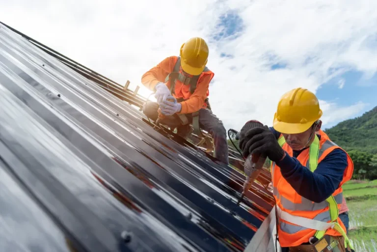 Two technicians fixing a metal roof